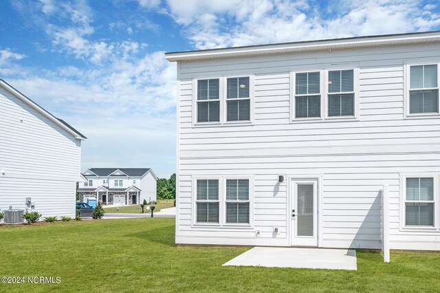 rear view of property with central AC, a patio, and a lawn
