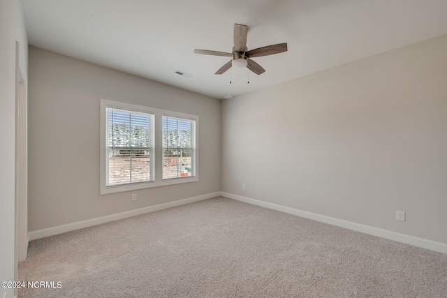 carpeted spare room featuring ceiling fan