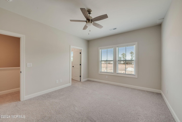 spare room featuring ceiling fan and light carpet