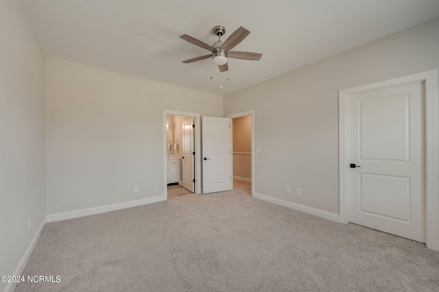 unfurnished bedroom with ensuite bathroom, ceiling fan, and light carpet