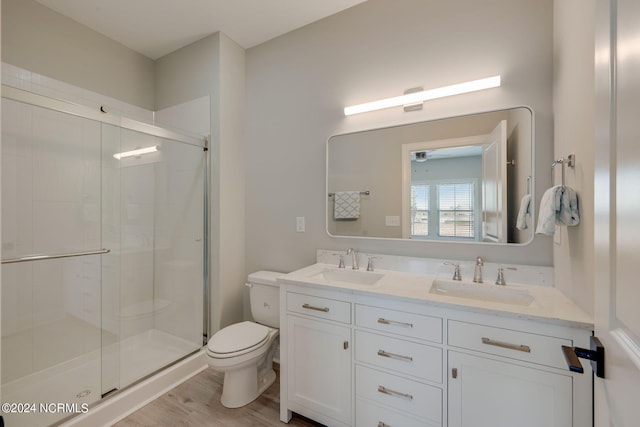 bathroom featuring vanity, toilet, an enclosed shower, and wood-type flooring