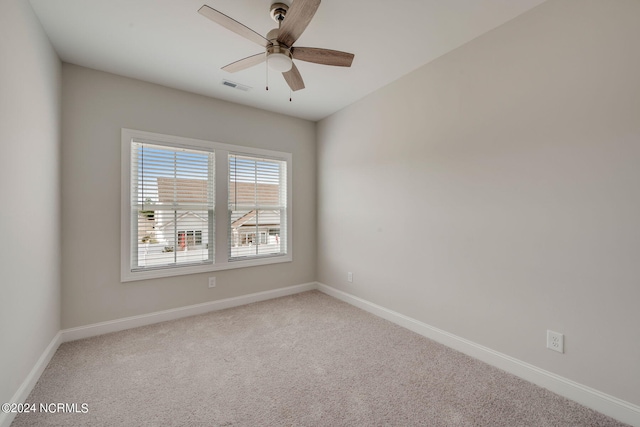 spare room with ceiling fan and carpet