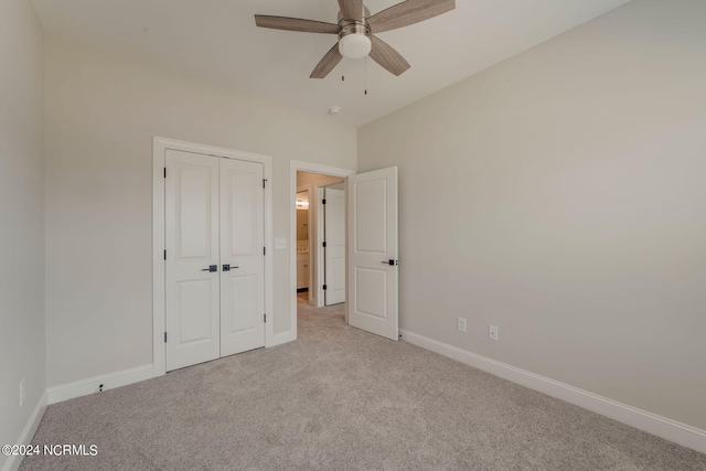 unfurnished bedroom with ceiling fan, a closet, and light colored carpet