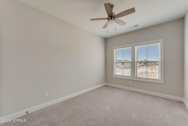 carpeted spare room featuring ceiling fan