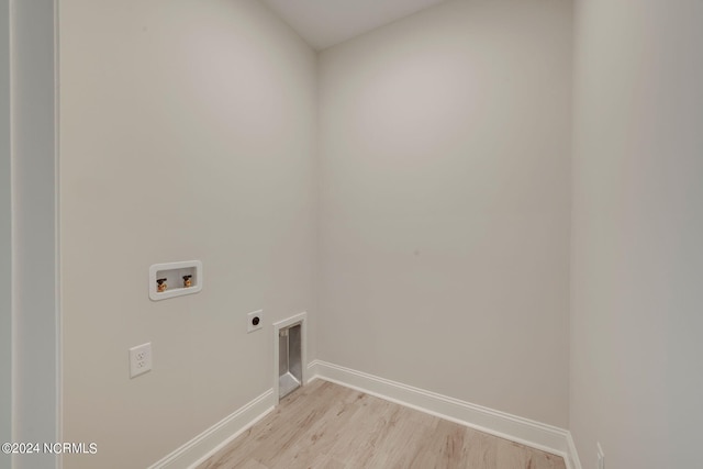 washroom featuring electric dryer hookup, hookup for a washing machine, and light hardwood / wood-style floors