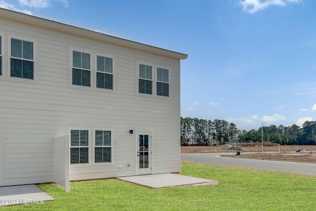 back of house featuring a lawn and a patio