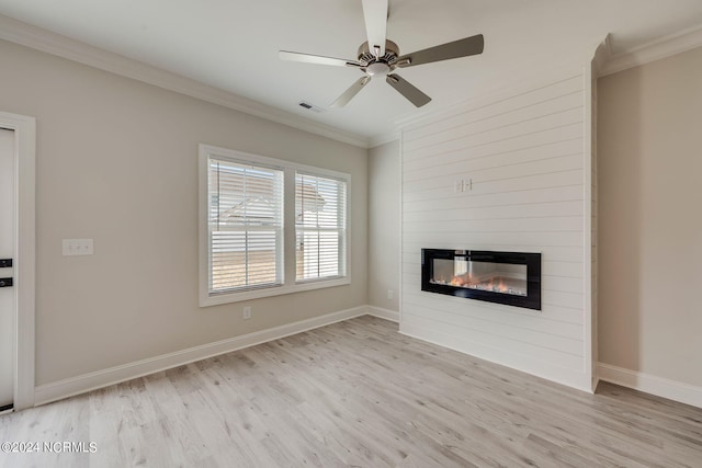 unfurnished living room with crown molding, a large fireplace, ceiling fan, and light hardwood / wood-style floors