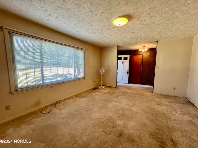 spare room with a textured ceiling and carpet floors