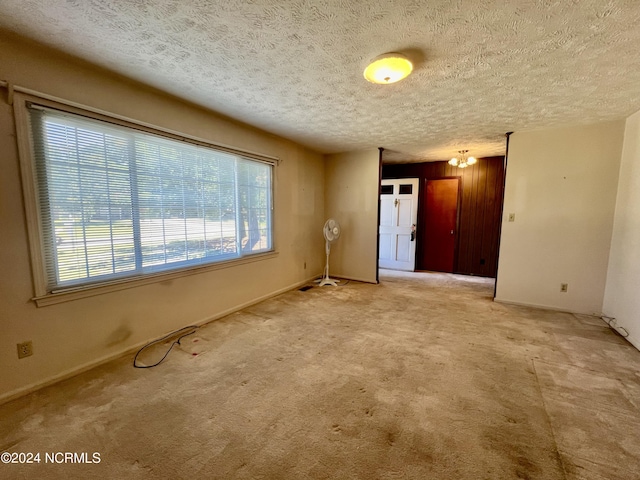 spare room featuring carpet floors and a textured ceiling