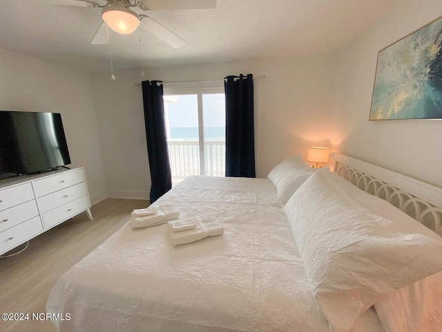 bedroom with a water view and ceiling fan