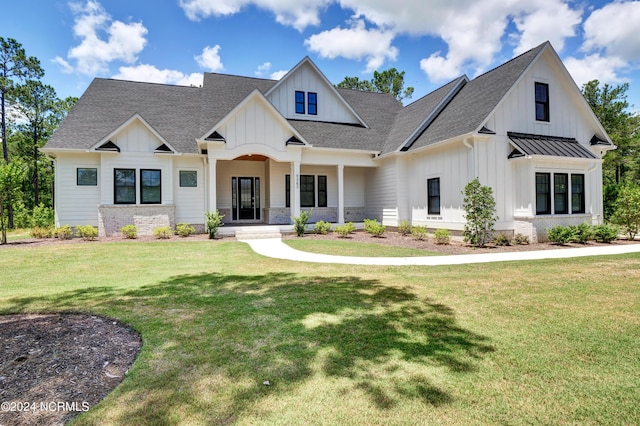 modern farmhouse with a shingled roof, brick siding, board and batten siding, a front lawn, and a standing seam roof