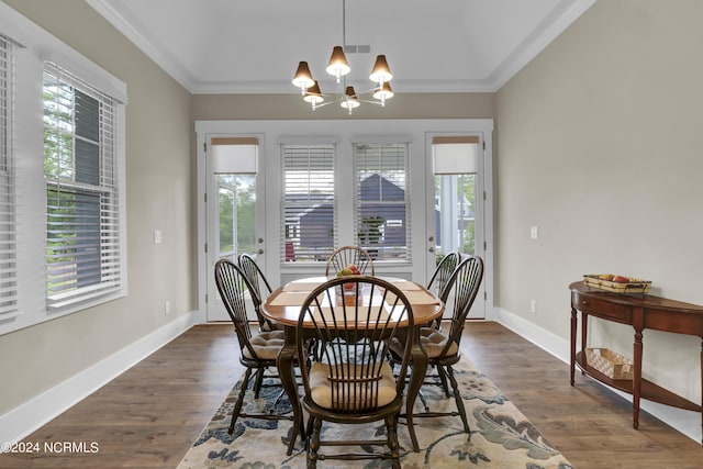 dining space featuring baseboards, visible vents, dark wood-style flooring, crown molding, and a chandelier