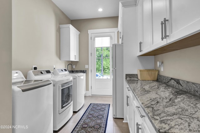 laundry room with light tile patterned floors, recessed lighting, cabinet space, and washer and dryer