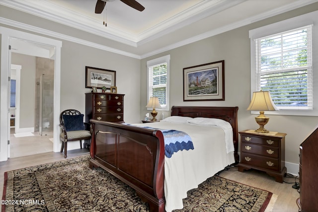 bedroom featuring ceiling fan, crown molding, ensuite bathroom, and wood finished floors