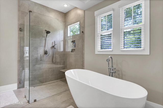 full bath with a stall shower, a soaking tub, and tile patterned floors