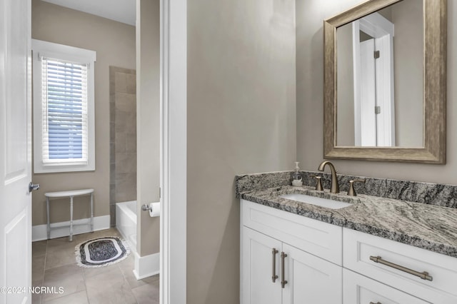 bathroom featuring baseboards, a tub, tile patterned flooring, walk in shower, and vanity