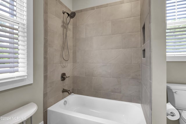 bathroom featuring shower / bath combination and toilet