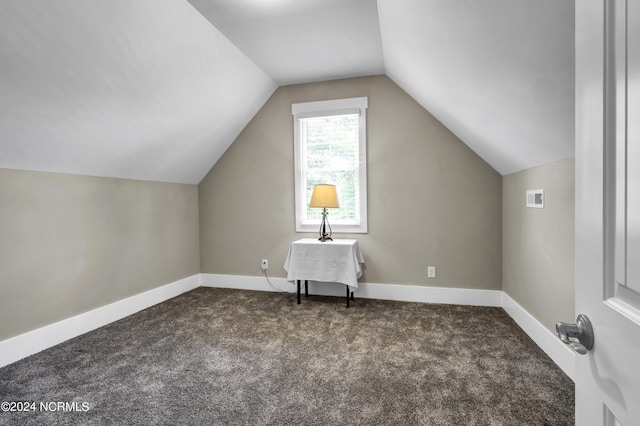 bonus room with dark carpet, baseboards, visible vents, and vaulted ceiling