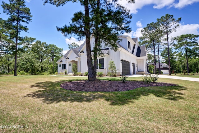 view of front of home with a garage, concrete driveway, a front lawn, and board and batten siding