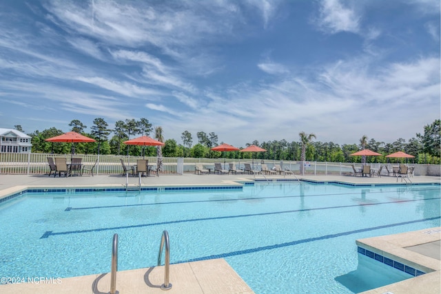 view of swimming pool featuring a patio area and fence