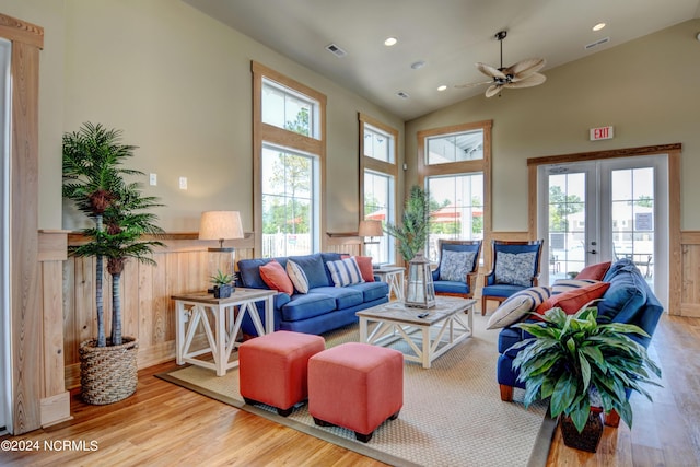 living room with french doors, a wainscoted wall, lofted ceiling, visible vents, and wood finished floors