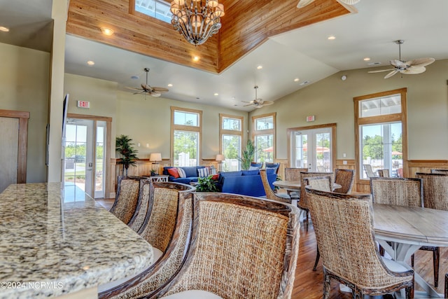 dining space with a wainscoted wall, french doors, wood finished floors, and a wealth of natural light