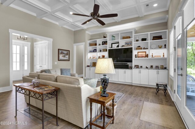 living area with coffered ceiling, ornamental molding, french doors, light wood-style floors, and beam ceiling