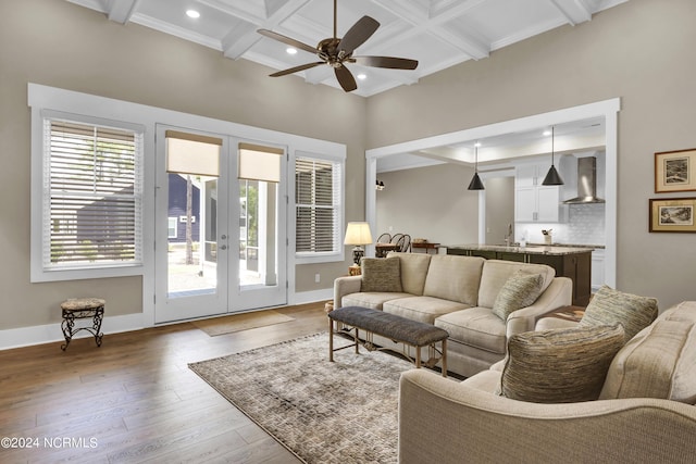 living area featuring baseboards, coffered ceiling, wood finished floors, french doors, and beam ceiling