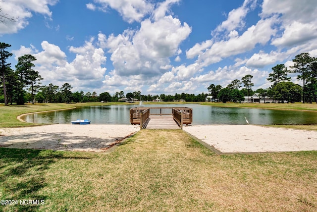 dock area with a water view and a yard