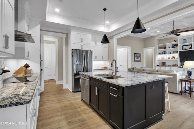 kitchen featuring a sink, white cabinetry, light wood-style floors, open floor plan, and appliances with stainless steel finishes