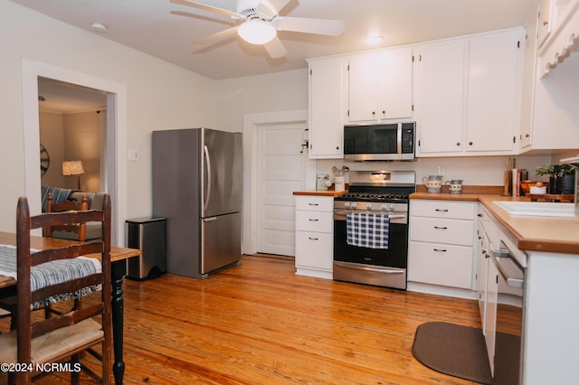 kitchen with white cabinets, sink, light hardwood / wood-style flooring, ceiling fan, and appliances with stainless steel finishes