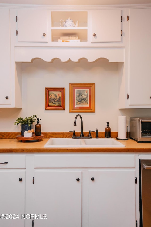 kitchen featuring white cabinetry and sink