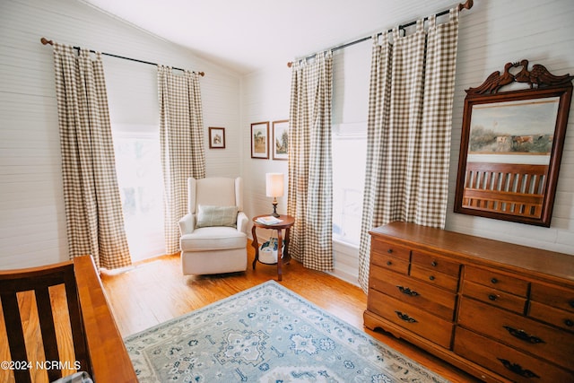 sitting room with hardwood / wood-style floors and vaulted ceiling