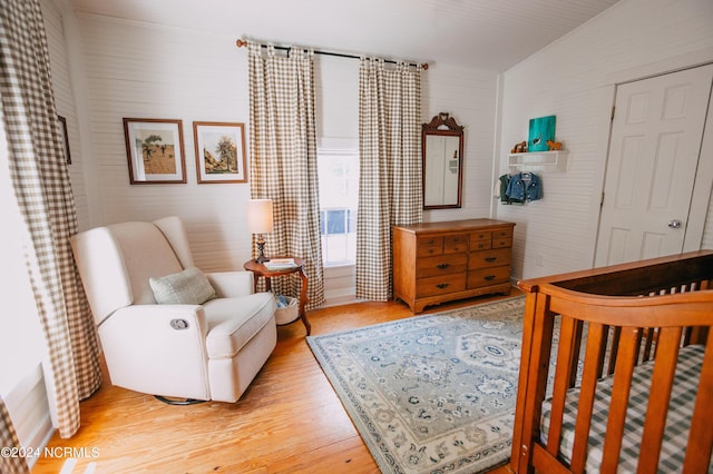 bedroom featuring a closet, light hardwood / wood-style flooring, and a nursery area