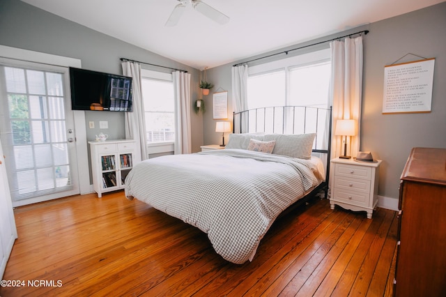 bedroom with hardwood / wood-style floors, ceiling fan, vaulted ceiling, and multiple windows