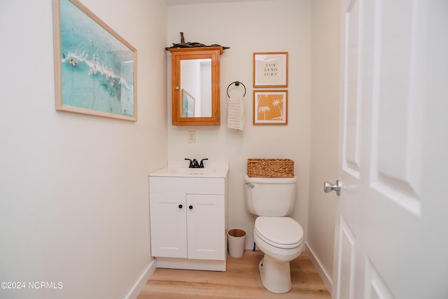 bathroom with hardwood / wood-style flooring, vanity, and toilet