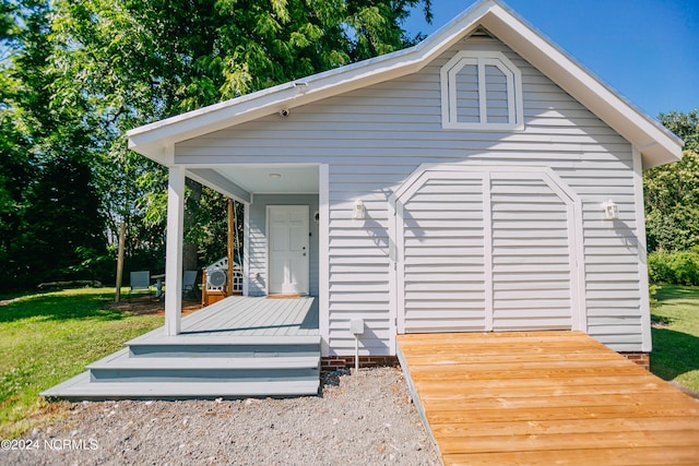 back of property with a yard and a deck