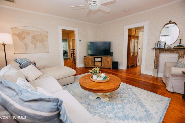 living room featuring ceiling fan, wood-type flooring, and crown molding