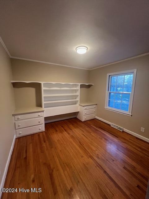 unfurnished room with dark hardwood / wood-style floors, ornamental molding, and a wealth of natural light