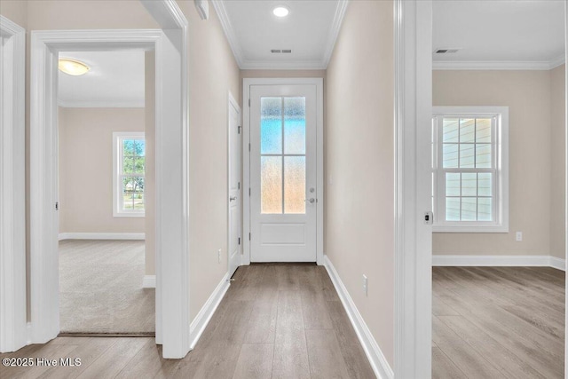 entryway with baseboards, visible vents, ornamental molding, and wood finished floors