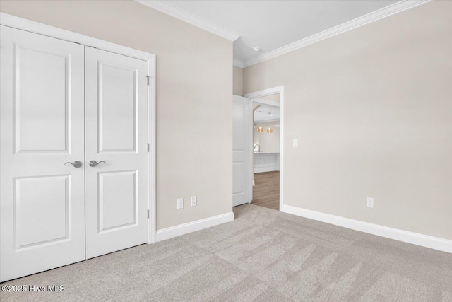 unfurnished bedroom featuring ornamental molding, a closet, carpet floors, and baseboards