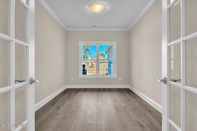 unfurnished room featuring ornamental molding, french doors, baseboards, and wood finished floors