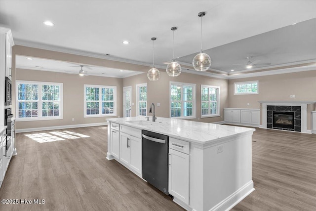 kitchen with a tile fireplace, open floor plan, a sink, and stainless steel dishwasher