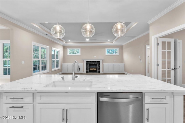 kitchen with a fireplace, a raised ceiling, stainless steel dishwasher, open floor plan, and a sink