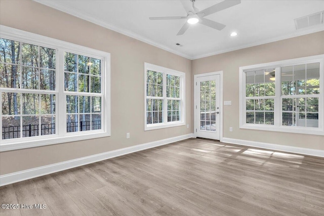 spare room featuring visible vents, crown molding, baseboards, and wood finished floors