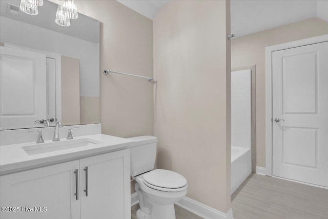 full bathroom with baseboards, vanity, and toilet