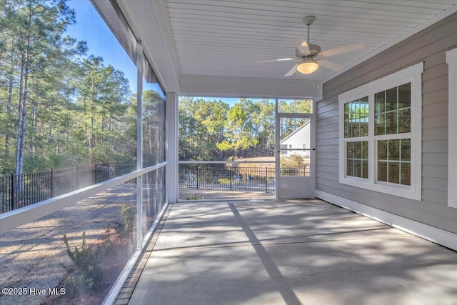 unfurnished sunroom featuring ceiling fan