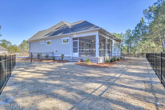 view of side of property with a sunroom and a fenced backyard