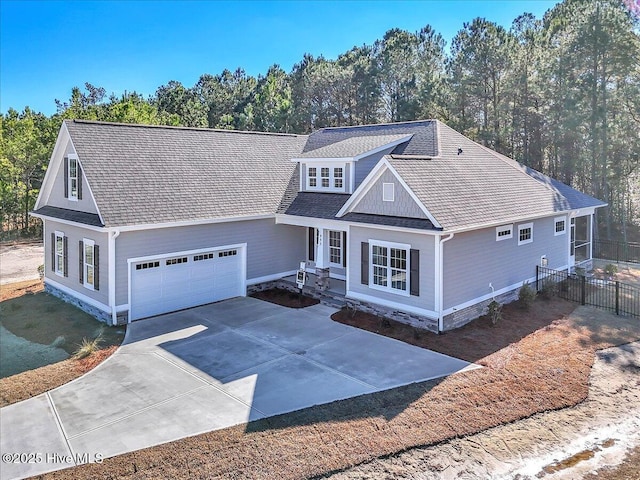 view of front facade featuring driveway, a shingled roof, a garage, and fence