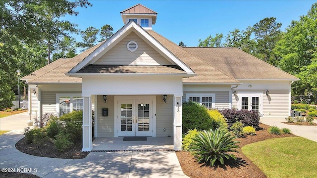 view of front of house featuring roof with shingles and french doors